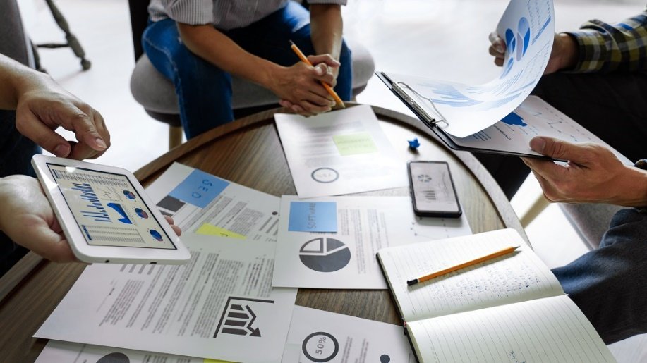 A group of people sitting at a table with papers
AI-generated content may be incorrect.